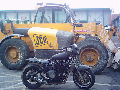 motorcycle in front of jcb digger